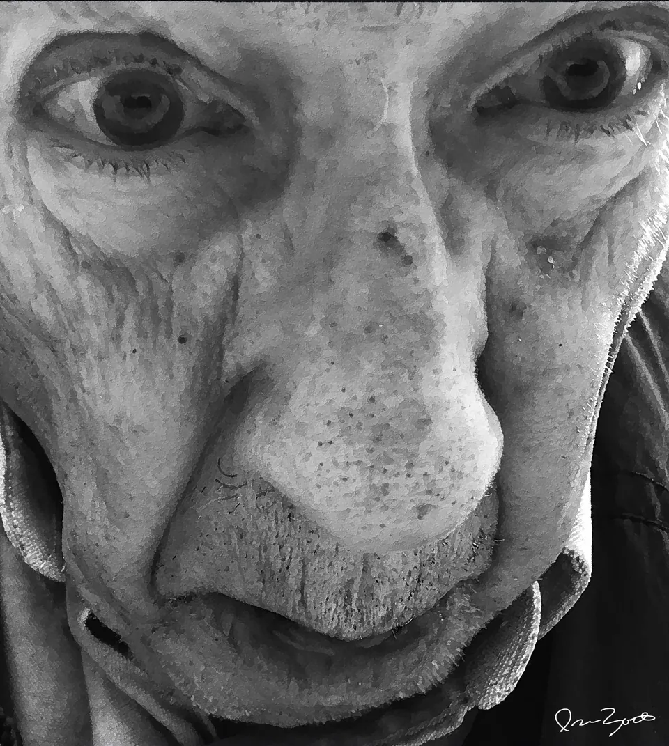Black and white extreme close-up photograph of an elderly man's face, eyes looking toward the camera.